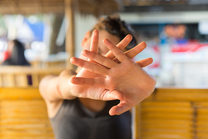 Young woman hide her face with hand. Focus on fingers.